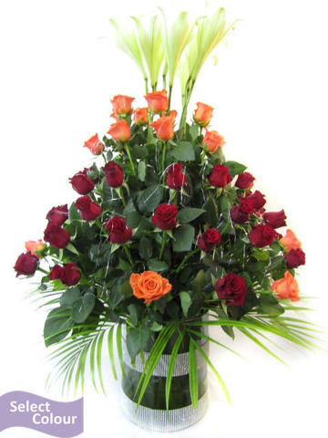 Roses and lilies arranged in cylinder vase